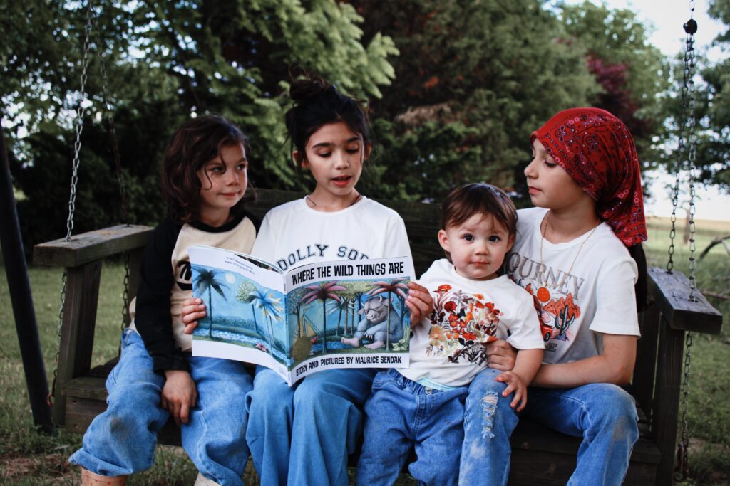 Girls reading a book together outside.